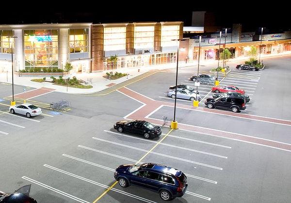 Retail store parking lot that is well lit with storefront lighting fixtures